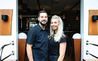 Die Gastgeber des Königsgarten stehen lächelnd im Eingang des Restaurants