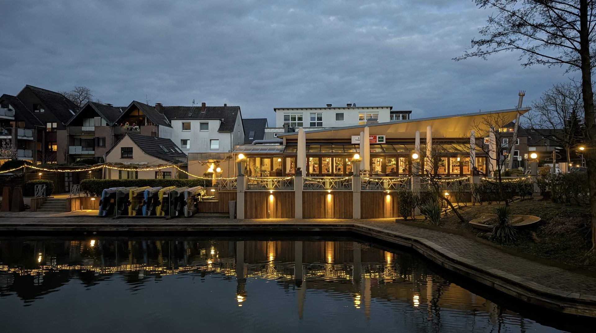 Beleuchtete Terrasse des Königsgarten am Wasser in der Abenddämmerung